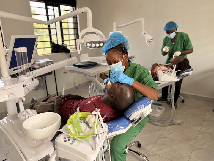 A Ugandan clinician treating a patient in a modern dental surgery