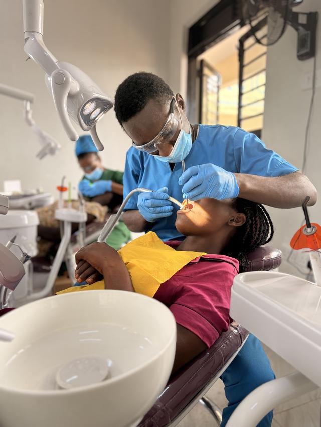 A Ugandan clinician treating a young patient