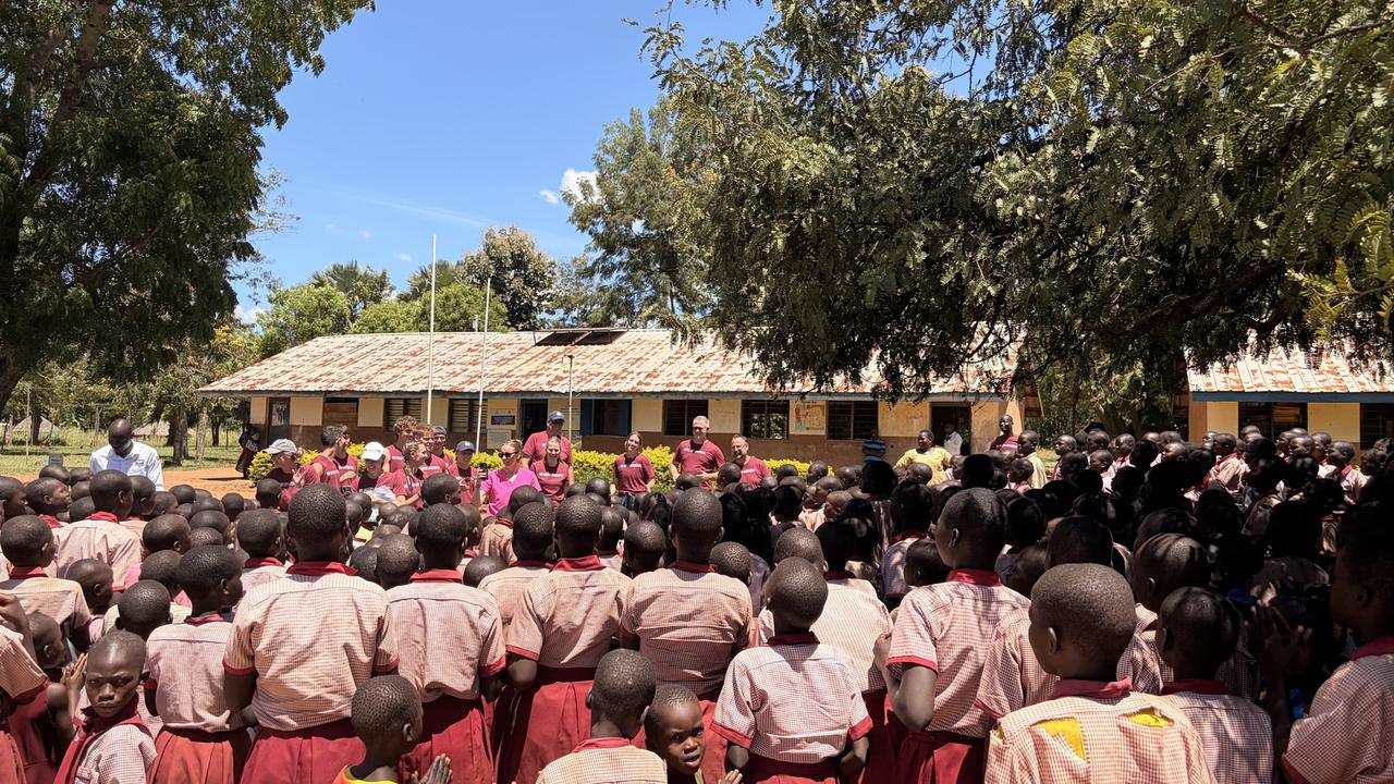 Hundreds of pupils in red and pink uniforms gathered at a school assembly